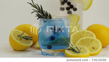 Cold drink in drinking glass. Refreshing soda lemonade blue cocktail with lemon Cold drink in drinking glass. Refreshing soda lemonade blue cocktail with lemon 53618490