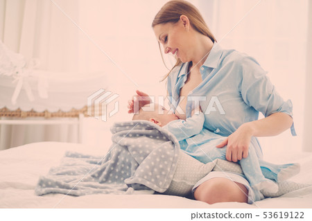Happy middle aged mother breast feeding her baby 53619122