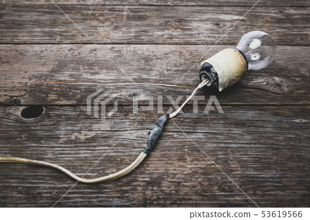 Retro lightbulb with damaged wires, vintage wooden 53619566