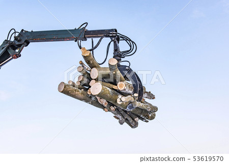 Hydraulic manipulator with logs, on sky background Hydraulic manipulator with logs, on sky background 53619570