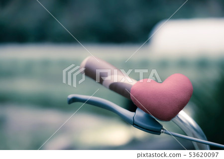 A little red heart pillow on the bicycle 53620097