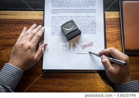 Close up hands of businessman signing and stamp on 53620749