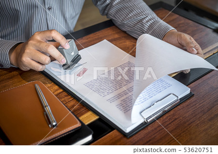 Hands of businessman stamp on paper document to 53620751
