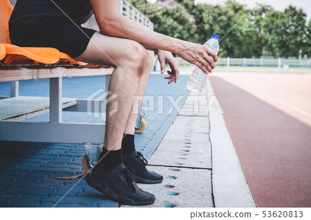 Young fitness athlete man resting on bench with 53620813