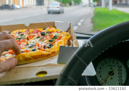 driver eats pizza in the car 53621192