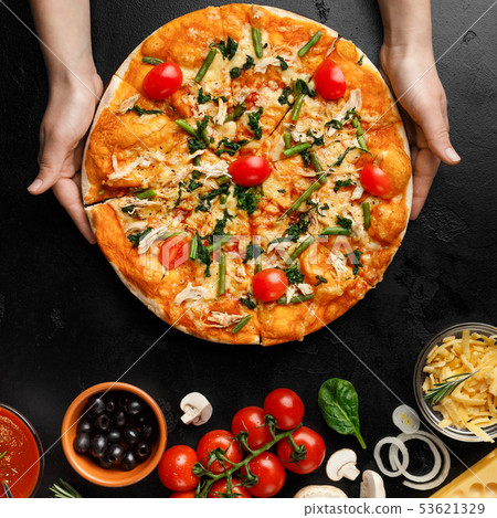 Woman Putting Homemade Pizza On Table, Crop 53621329