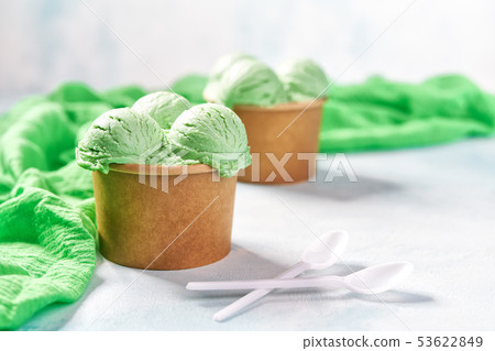two portions pistachio ice cream in paper cup and two portions pistachio ice cream in paper cup and 53622849
