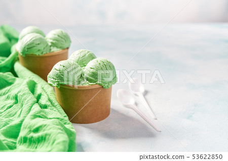 two portions pistachio ice cream in paper cup and two portions pistachio ice cream in paper cup and 53622850