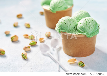 two portions pistachio ice cream in paper cup on two portions pistachio ice cream in paper cup on 53622852