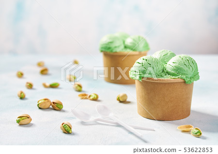 two portions pistachio ice cream in paper cup on 53622853