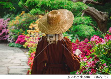 style woman near rhododendron flowers in a grarden 53622967