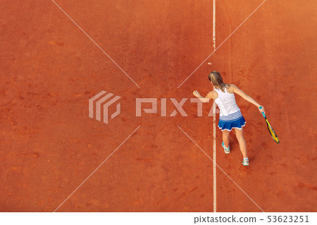 Aerial shot of a female tennis player on a court during match. Young woman playing tennis.High angle 53623251