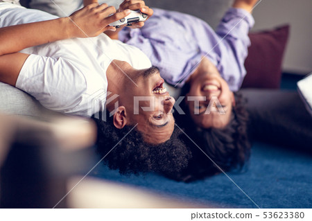 Young smiling couple playing videogames at home. Young smiling couple playing videogames at home. 53623380