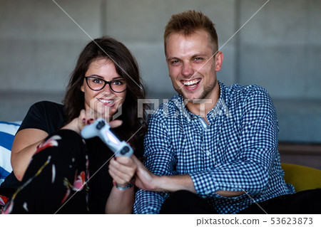 Young smiling couple playing videogames at home. Young smiling couple playing videogames at home. 53623873