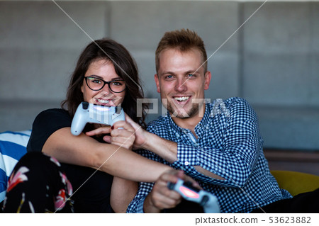 Young smiling couple playing videogames at home. Young smiling couple playing videogames at home. 53623882