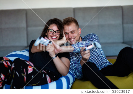 Young smiling couple playing videogames at home. Young smiling couple playing videogames at home. 53623917