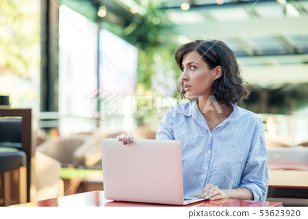 young and beautiful girl with notebook and laptop sitting in a cafe young and beautiful girl with notebook and laptop sitting in a cafe 53623920