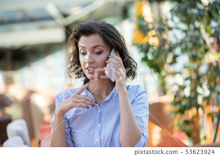 Candid image of a businesswoman working in a cafe. Selective focus. 53623924