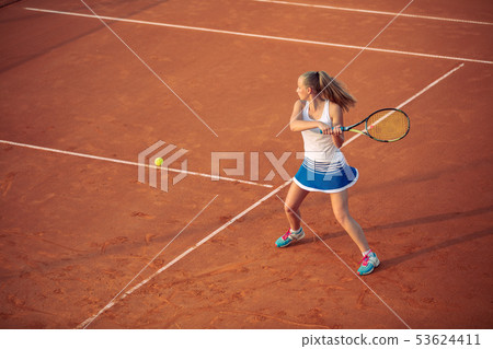 Woman playing tennis on clay court, with sporty outfit and healthy lifestyle 53624411