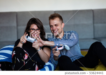 Young smiling couple playing videogames at home. 53624441