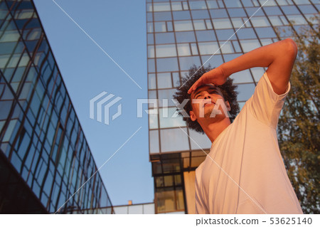 happy smiling urban hipster young man using smart phone. African american teenager holding mobile 53625140