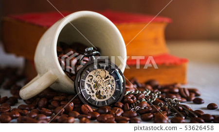 Pocket watch and coffee cup on coffee seed. Pocket watch and coffee cup on coffee seed. 53626458