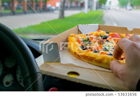 driver eats pizza in the car 53631656