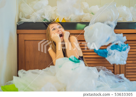 Woman used too many plastic bags that they filled up the entire kitchen. Zero waste concept. The Woman used too many plastic bags that they filled up the entire kitchen. Zero waste concept. The 53633305