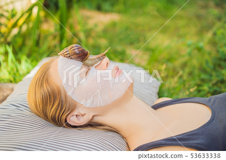 Young woman makes a face mask with snail mucus. Snail crawling on a face mask 53633338
