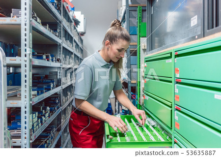Woman in storeroom of key maker store Woman in storeroom of key maker store 53635887