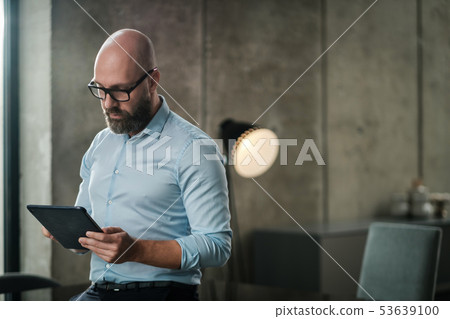 Middle-aged man with a tablet pc in an office 53639100