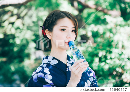 A woman in a yukata drinking ramune 53640537