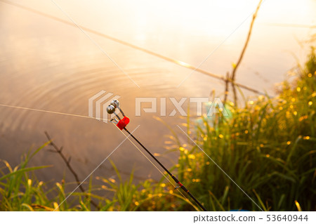 Fishing at foggy lake in the early morning just after golden sunrise. Fishing bell closeup 53640944
