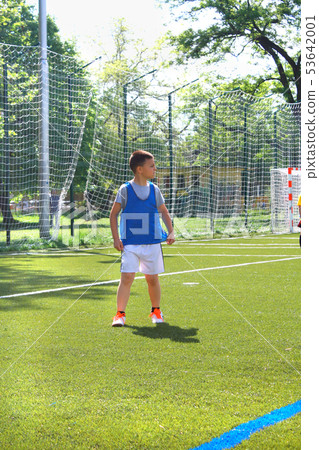 Boy playing soccer at soccer field. Boy playing soccer at soccer field. 53642001