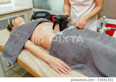 Beauty therapist applying cryolipolysis treatment. Beauty therapist applying cryolipolysis treatment. 53642381