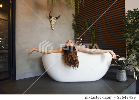 Happy young woman relaxing in bathtub Happy young woman relaxing in bathtub 53642459