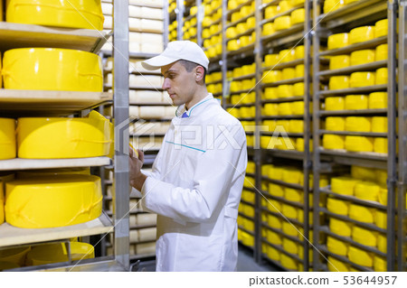 Portrait of inspector standing in production department of dairy factory and take view of redy Portrait of inspector standing in production department of dairy factory and take view of redy 53644957