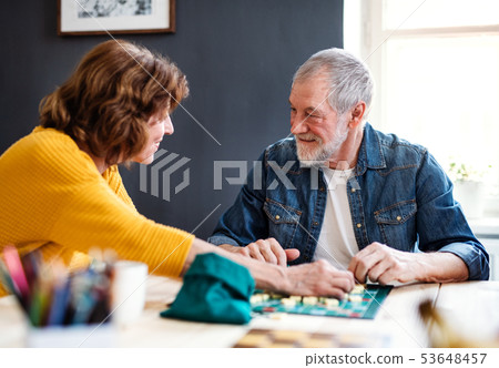 Senior couple playing board games in community center club. Senior couple playing board games in community center club. 53648457
