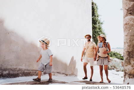 A family with two toddler children walking in town on summer holiday. A family with two toddler children walking in town on summer holiday. 53648576