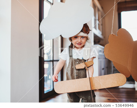 A toddler boy with carton plane playing indoors at home, flying concept. 53649946