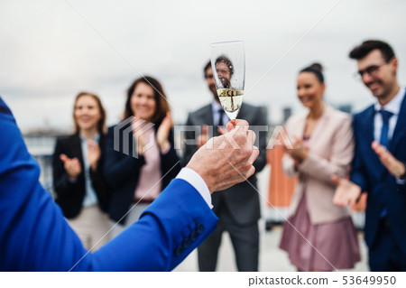 A group of joyful businesspeople having a party outdoors on roof terrace in city. 53649950