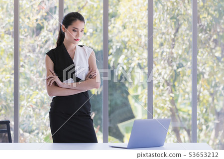 Asian businesswoman looking at laptop in office.. Asian businesswoman looking at laptop in office.. 53653212