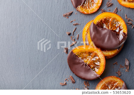 Candied orange slices in chocolate. Slate background. Top view. Copy space. Candied orange slices in chocolate. Slate background. Top view. Copy space. 53653620