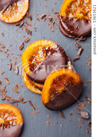 Candied orange slices in chocolate. Slate background. Top view. Candied orange slices in chocolate. Slate background. Top view. 53653621