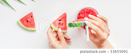 Woman hands with watermelon smoothie drink glass Woman hands with watermelon smoothie drink glass 53655091