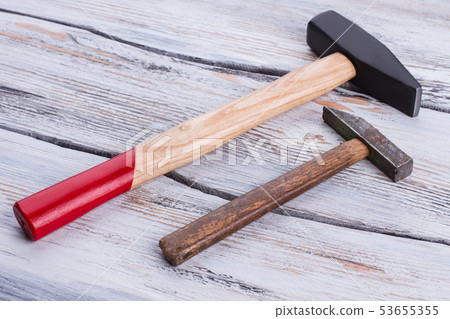 Old and new hammers on wooden background. Old and new hammers on wooden background. 53655355