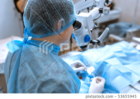 ophthalmologist surgeon looking through surgical 53655945