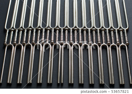 Tuning fork pattern on a black background Tuning fork pattern on a black background 53657821
