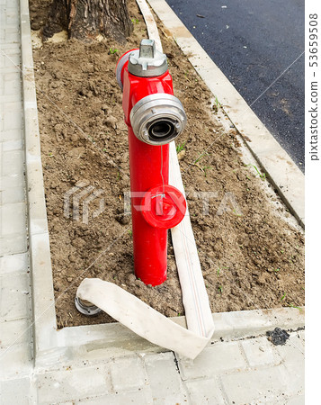Red fire hydrant and white fire hose without water Red fire hydrant and white fire hose without water 53659508