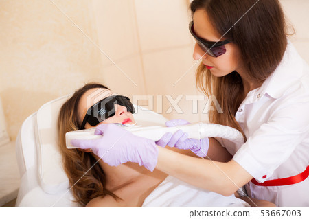 Skin care. Woman receiving laser epilation treatment on her face 53667003